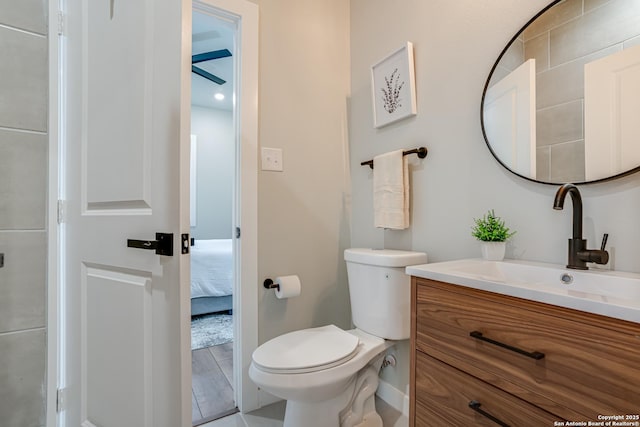 bathroom with ceiling fan, vanity, wood-type flooring, and toilet