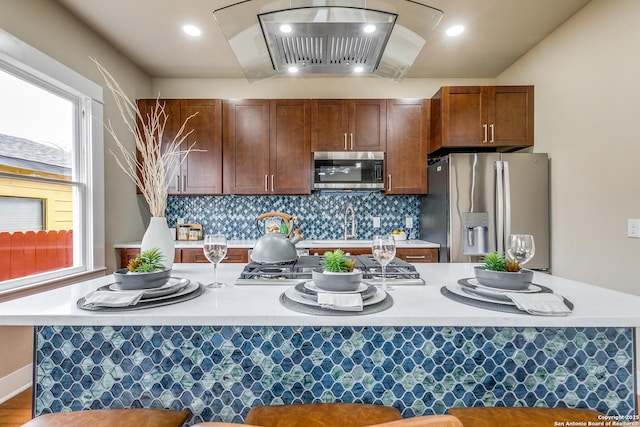 kitchen featuring hardwood / wood-style floors, backsplash, and appliances with stainless steel finishes