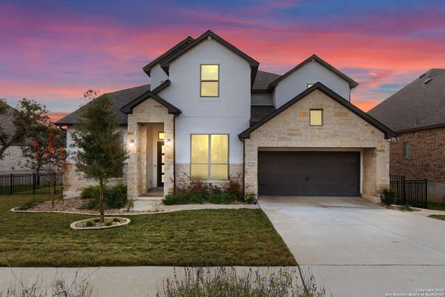 view of front of house featuring a garage and a lawn