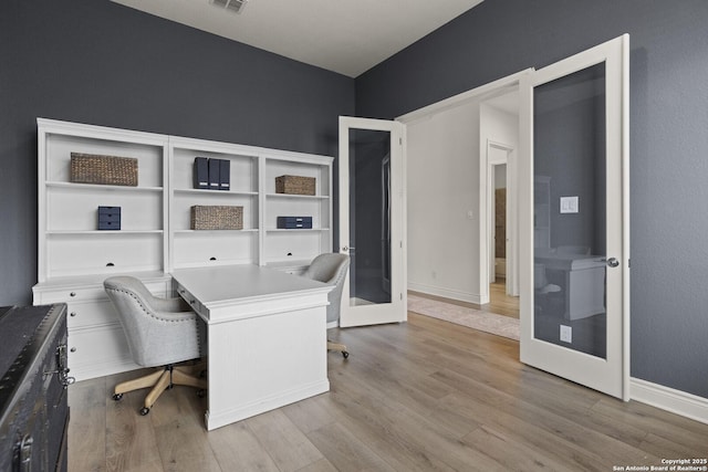 office space with light wood-type flooring and french doors