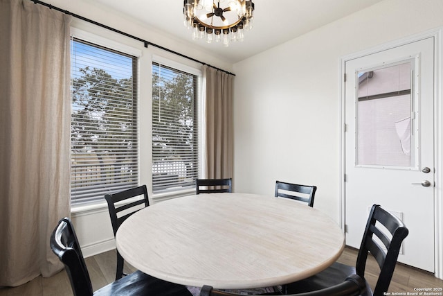 dining area with hardwood / wood-style floors and an inviting chandelier