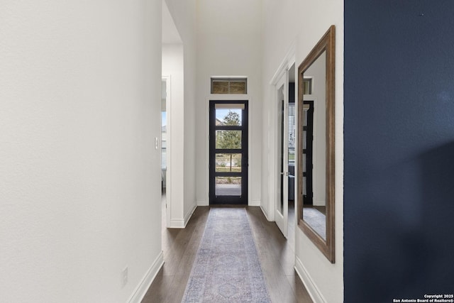 doorway with dark wood-type flooring, a high ceiling, and french doors