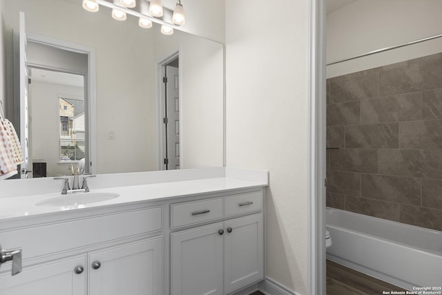 full bathroom with vanity, tiled shower / bath combo, hardwood / wood-style flooring, and toilet