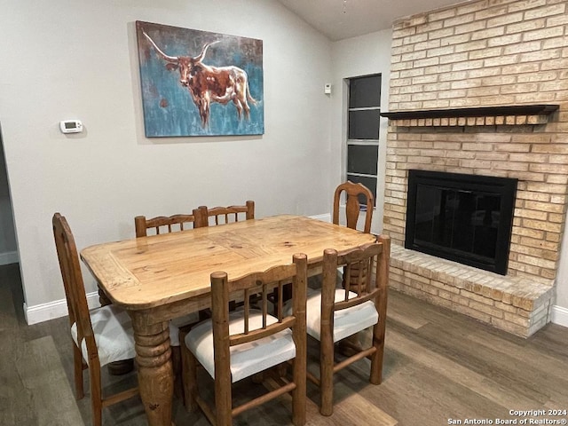 dining room with a fireplace and dark wood-type flooring