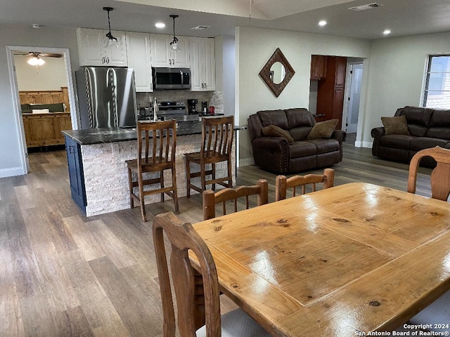 dining room with hardwood / wood-style floors and ceiling fan