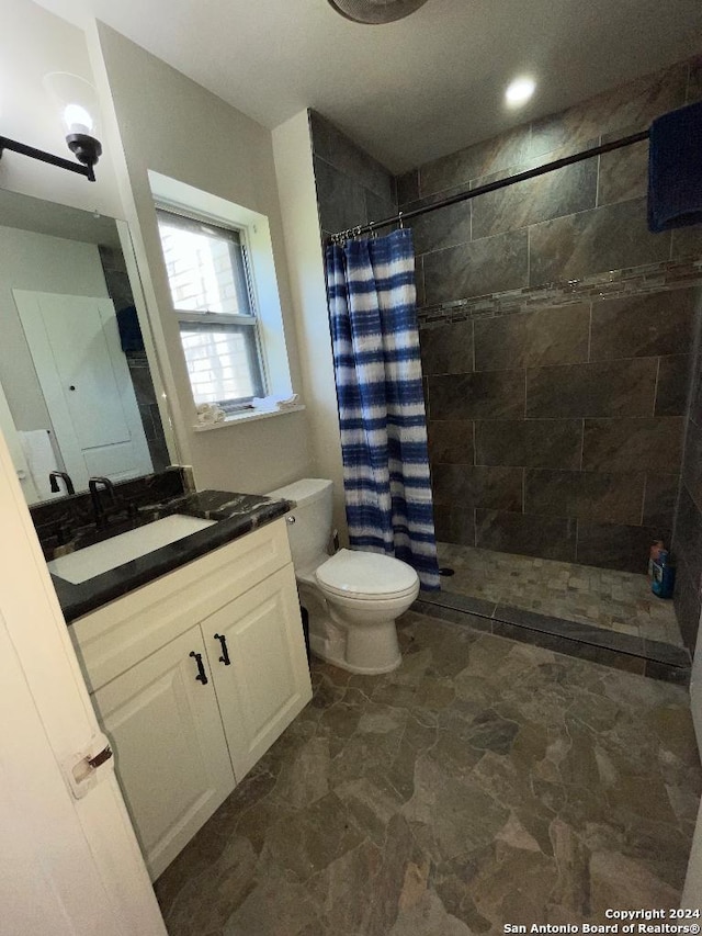 bathroom featuring a shower with shower curtain, vanity, and toilet