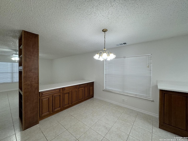 unfurnished dining area with ceiling fan with notable chandelier