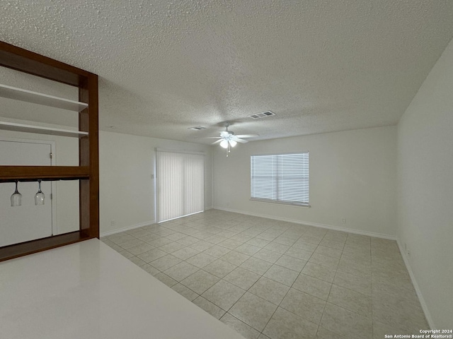 interior space with ceiling fan and a textured ceiling