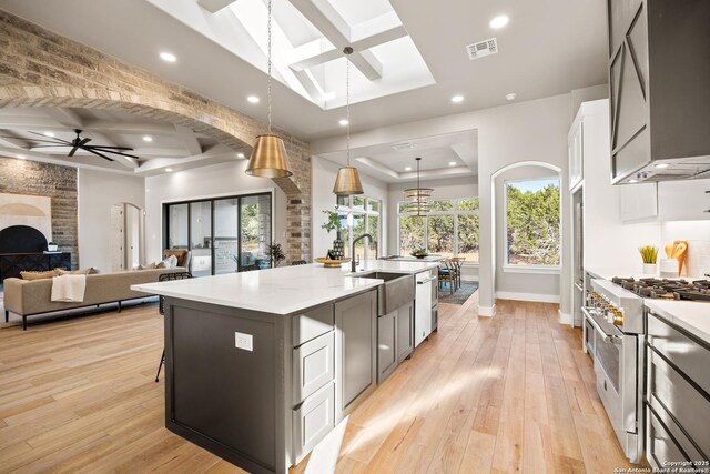 kitchen with ceiling fan, sink, a spacious island, pendant lighting, and appliances with stainless steel finishes