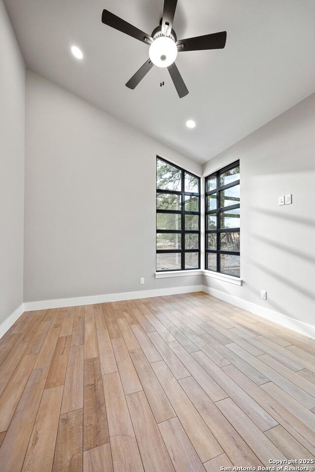 spare room featuring ceiling fan and light hardwood / wood-style flooring