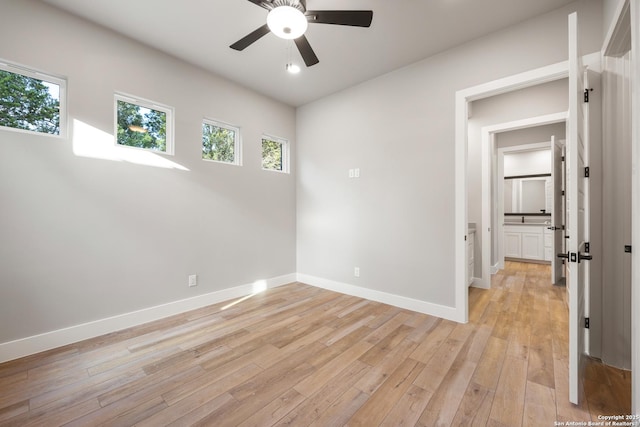 empty room with ceiling fan and light hardwood / wood-style flooring