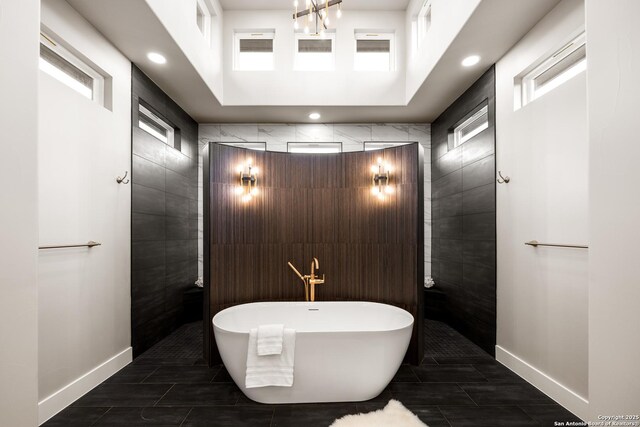 bathroom with a bathing tub, plenty of natural light, and tile walls