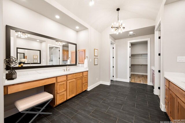 bathroom featuring vanity, vaulted ceiling, and a notable chandelier