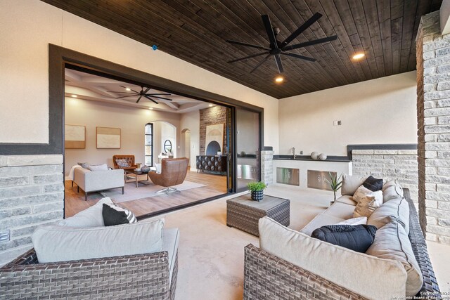 living room with ceiling fan, concrete floors, and wood ceiling