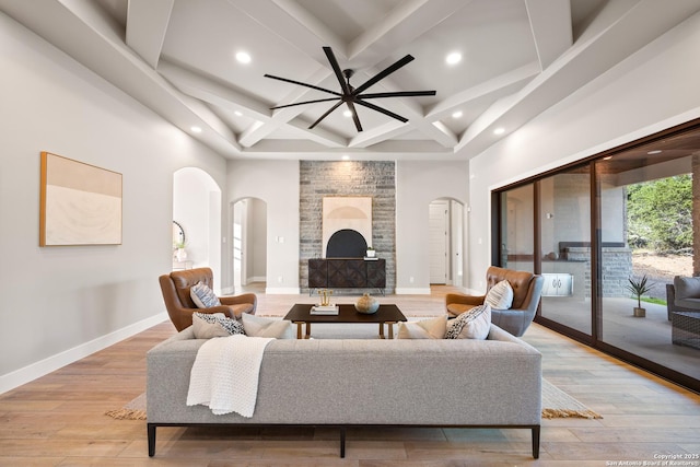 living room with beamed ceiling, ceiling fan, light wood-type flooring, and coffered ceiling