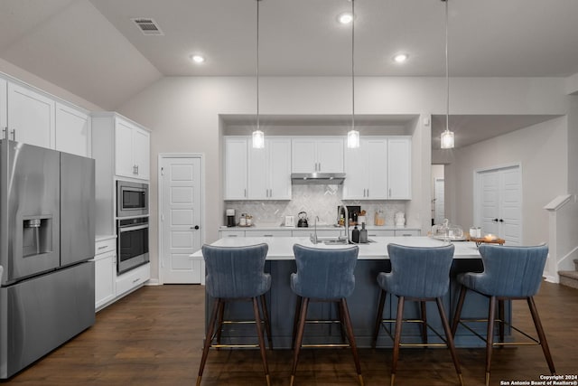 kitchen with white cabinetry, pendant lighting, stainless steel appliances, and a center island with sink