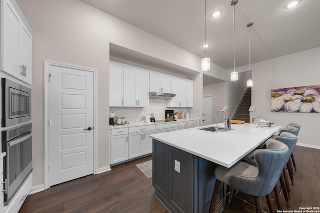 kitchen featuring white cabinets, decorative light fixtures, sink, and stainless steel appliances