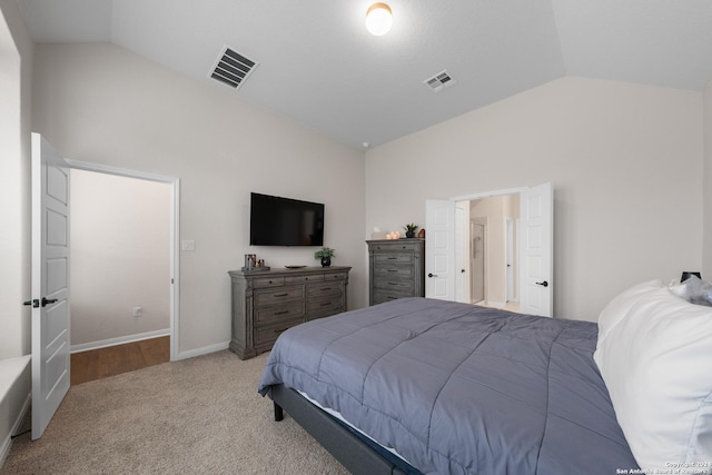 carpeted bedroom featuring lofted ceiling