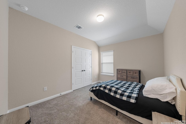 bedroom featuring a textured ceiling, a closet, and lofted ceiling