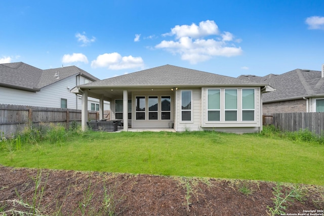 rear view of property with a yard