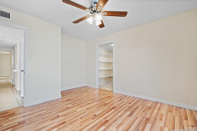 empty room with ceiling fan and light hardwood / wood-style floors