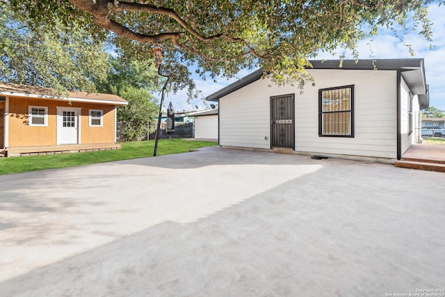 back of property with a yard and a shed