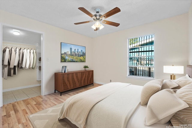 bedroom with a closet, light hardwood / wood-style flooring, and ceiling fan