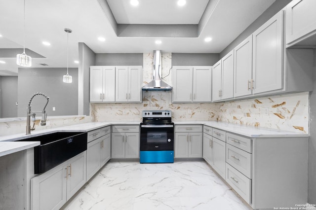 kitchen featuring tasteful backsplash, sink, wall chimney range hood, pendant lighting, and stainless steel range with electric cooktop