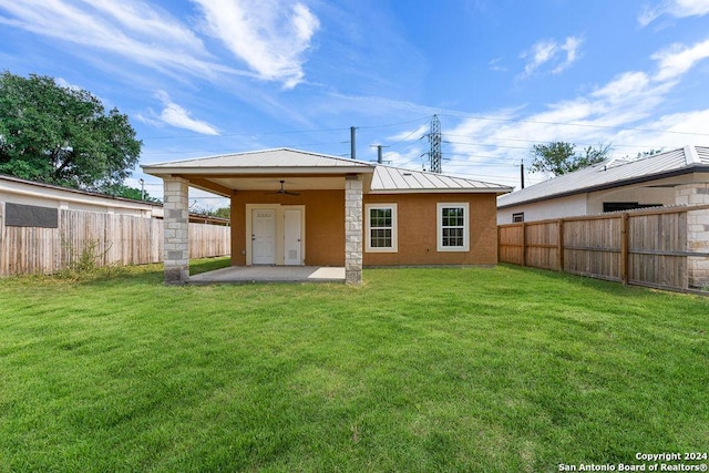 rear view of property featuring a yard, a patio, and ceiling fan