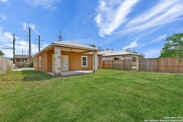 rear view of house featuring a yard, a patio, and ceiling fan