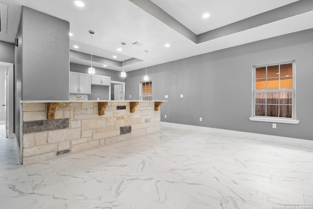 unfurnished living room featuring a tray ceiling