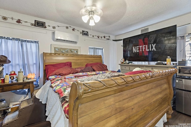 bedroom featuring hardwood / wood-style floors, ceiling fan, a textured ceiling, and a wall unit AC