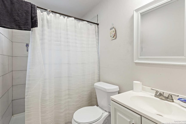 bathroom with vanity, toilet, and walk in shower