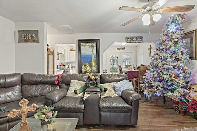 living room with hardwood / wood-style floors, ceiling fan, and french doors