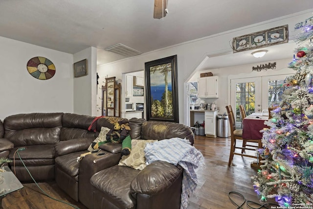 living room featuring ceiling fan, dark wood-type flooring, and french doors