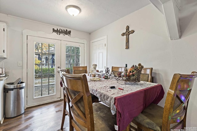 dining room with wood-type flooring, a textured ceiling, and a wealth of natural light