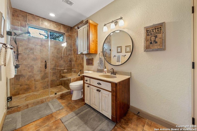 bathroom featuring vanity, toilet, and a shower with door