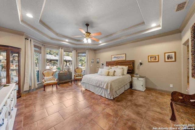 bedroom with a textured ceiling, ceiling fan, crown molding, and a tray ceiling