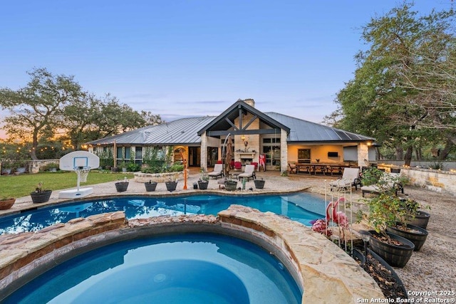 view of swimming pool featuring exterior bar, a patio, and an in ground hot tub