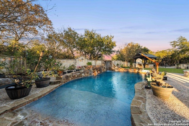 pool at dusk with pool water feature