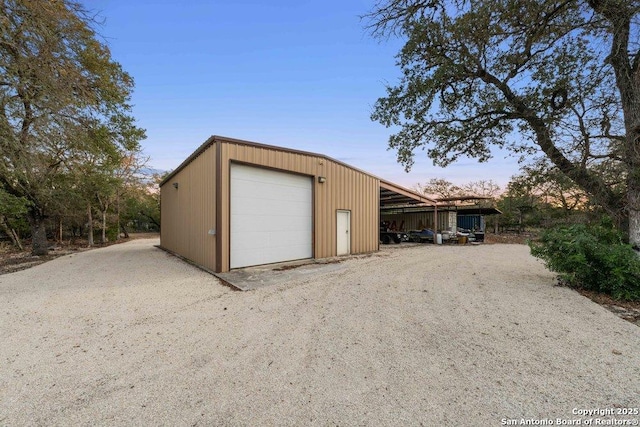 garage at dusk featuring a carport