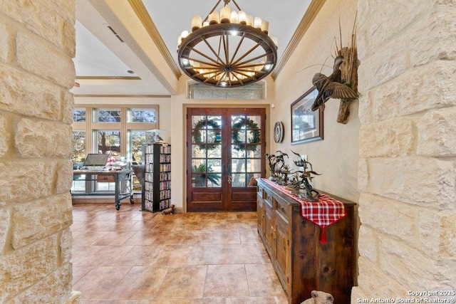 foyer entrance with french doors, a healthy amount of sunlight, an inviting chandelier, a towering ceiling, and ornamental molding