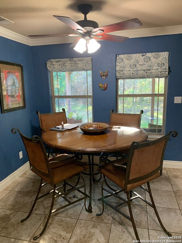 tiled dining area featuring ceiling fan, plenty of natural light, and ornamental molding