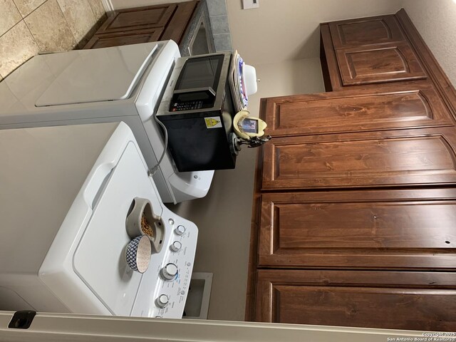 laundry room featuring cabinets and washing machine and dryer