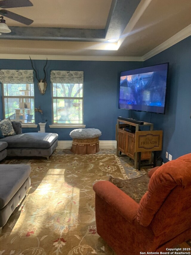 living room with ceiling fan, crown molding, and a tray ceiling