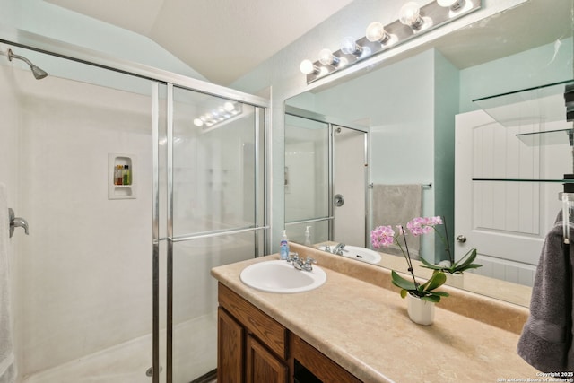 bathroom featuring vanity, a shower with shower door, and lofted ceiling