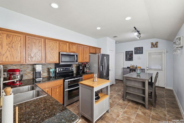 kitchen featuring sink, decorative backsplash, butcher block countertops, a kitchen island, and stainless steel appliances