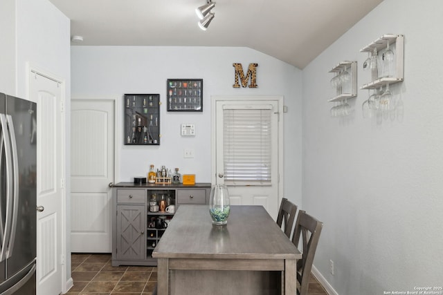 tiled dining room with bar area and lofted ceiling