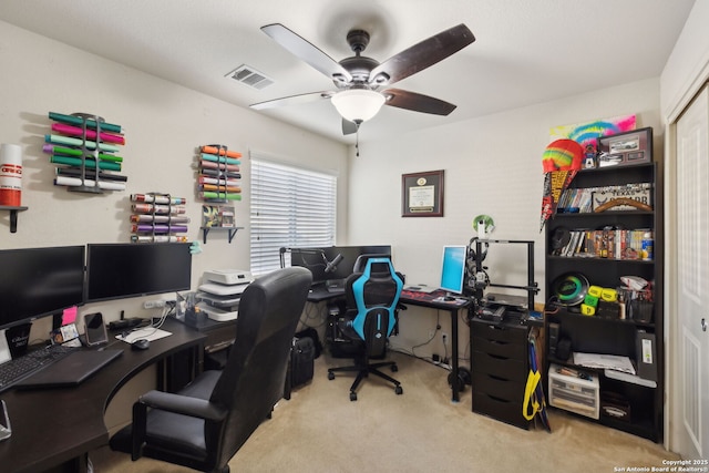 carpeted home office featuring ceiling fan