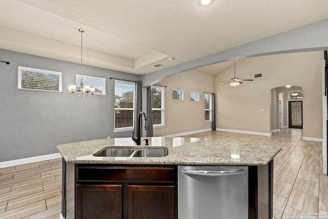 kitchen featuring dark brown cabinetry, a kitchen island with sink, sink, and stainless steel dishwasher